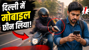 दिल्ली की सड़क पर एक युवक मोबाइल इस्तेमाल कर रहा है तभी पीछे से बाइक सवार बदमाश उसका फोन छीनते हुए दिखाई दे रहा है, तेज रफ्तार और झपटमारी की घटना को दर्शाता दृश्य